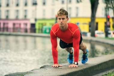 Genç erkek şınav çekiyor. Açık havada egzersiz yapmak..