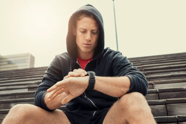 Antrenmandan sonra şehir koşucusu kalp atış hızı monitörüne bakıyor.