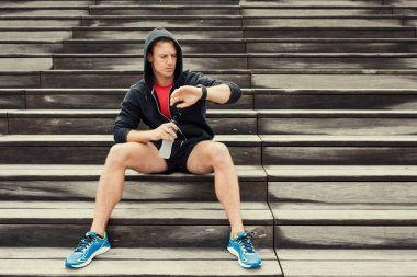 Antrenmandan sonra şehir koşucusu kalp atış hızı monitörüne bakıyor.