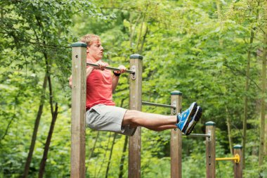 Parktaki barın üstünde şınav çeken erkek sporcu. Dışarıda çalış.
