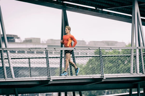 Bieganie Męskim Joggingiem Graficznym Metalowym Moście — Zdjęcie stockowe