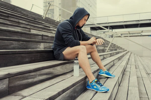 Şehir sporcusu antrenmandan sonra kalp atış hızı monitörüne bakıyor.