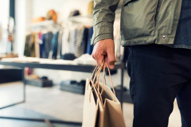 Man shopping in clothing store carry a paper bag