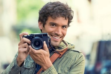 Sokakta neşeli bir fotoğrafçı var. Kameraya bakıyorum.