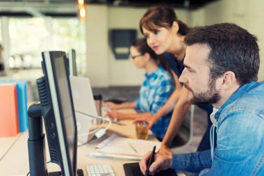 Modern başlangıç alanında yaratıcı ekibiyle birlikte çalışan kadın yönetici.