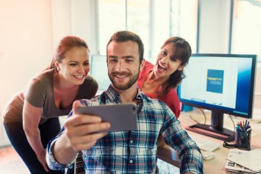 Modern ofiste Selfie çeken sıradan yaratıcı bir ekip.