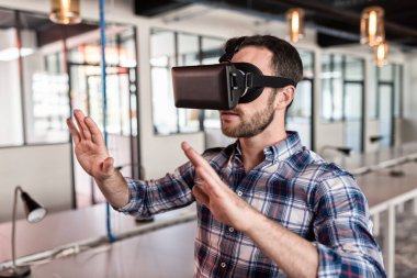 Man using virtual reality glasses in startup office.