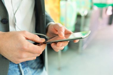 Man using his cell phone. listen music . At bus. texting  message. Close-up hands