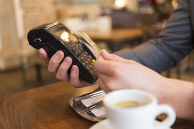Man paying with NFC technology , credit card, in restaurant, bar, cafe