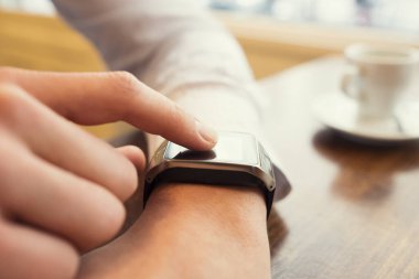 Man in a bar using smart watch. Close-up finger. Vintage filter