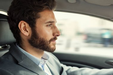Genç adam araba kullanıyor.
