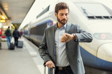 Adam istasyonda saatine bakıyor.