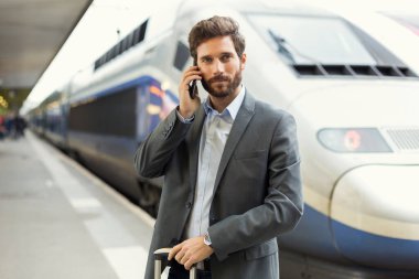 Telefondaki adam. Platform istasyonu. Arkaplanda tren