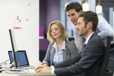 Group of business people in a meeting at office, working on comp