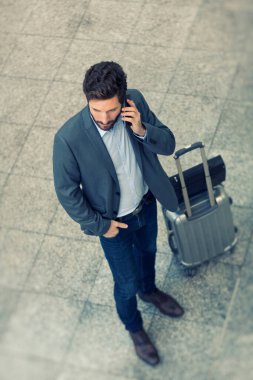 Koridordaki havaalanında cep telefonuyla konuşan modern bir iş adamı. Üst Görünüm