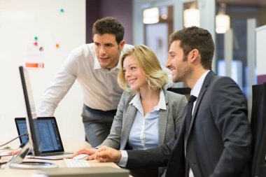 Group of business people in a meeting at office, working on comp