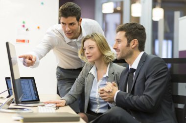 Group of business people in a meeting at office, working on comp