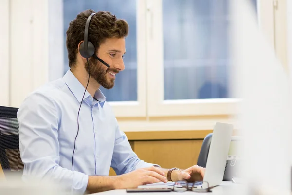 Ευτυχισμένος Επιχειρηματίας Στο Γραφείο Στο Τηλέφωνο Ακουστικά Skype — Φωτογραφία Αρχείου