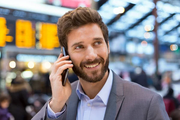 Hall istasyonu önünde kurulu programları cep telefonunda neşeli adam