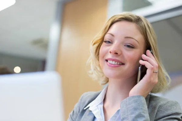 現代のオフィスで携帯電話で話すビジネスマンの女性 ストック画像