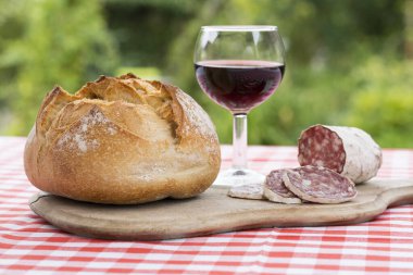 Doğal ahşap masada şarap ile salam dilimleri 