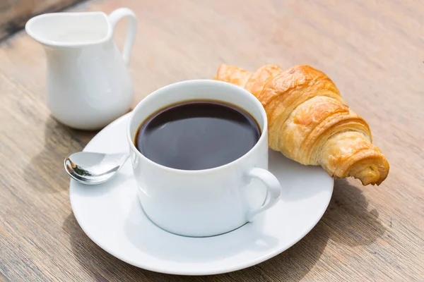 黒コーヒーとクロワッサンのカップで朝食 — ストック写真