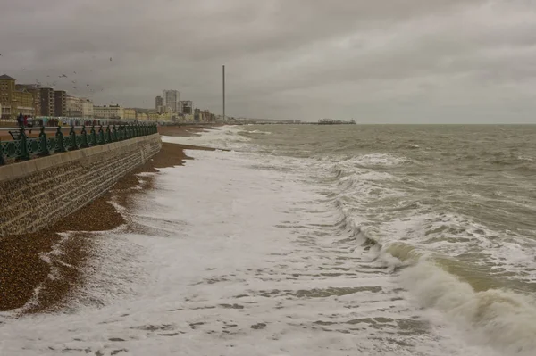 英格兰东萨塞克斯郡布莱顿海滨的灰蒙蒙的风暴天气 与难以辨认的人在人行道上 — 图库照片
