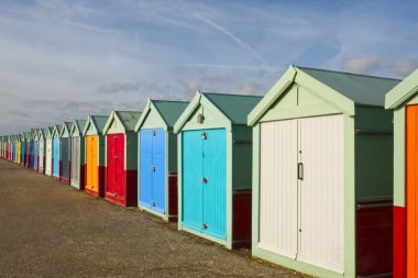 Doğu Sussex, İngiltere 'deki Hove, Brighton' da deniz kenarında renkli sahil kulübeleri.