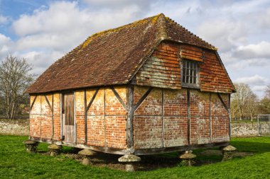 Tipik Sussex ahırı Staddle Stones (haşaratların tahıl ambarına tırmanmasını önlemek için). Sussex, İngiltere