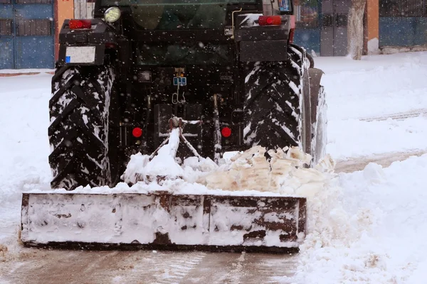 La limpieza de la calle de la nieve por el tractor en la calle —  Fotos de Stock