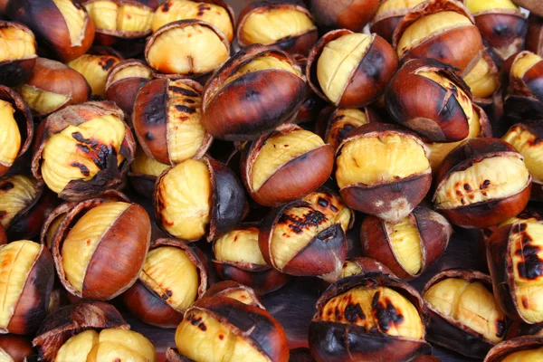 Deliciosas castanhas grelhadas como fundo — Fotografia de Stock