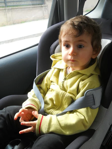 Bebé en el asiento del coche para la seguridad, mirando fuera — Foto de Stock