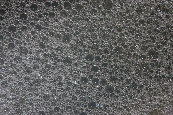 Textura de água de sabão em um fundo preto — Fotografia de Stock