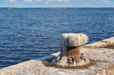 Eski bir demir yığını kıyıya yakın, beton bir plakanın üzerinde, gemiyi bağlamak için.
