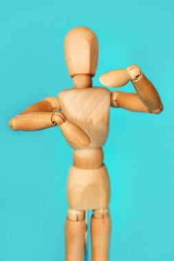 Sarı ahşap manken elleriyle hareket ediyor.