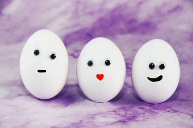 Mor arkaplanda gözleri olan beyaz paskalya yumurtaları