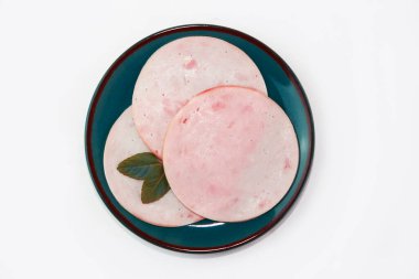 Mavi bir tabakta ince dilimlenmiş et sosisi parçaları.