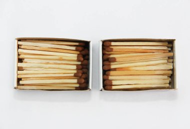 Sarı ahşap kibrit, beyaz arka plandaki karton kutunun içindeki sülfür başıyla eşleşiyor.