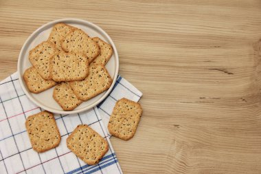 Dekoratif cam tabakta siyah kimyon ve kinoa içeren kuru kare diyet krakerleri.