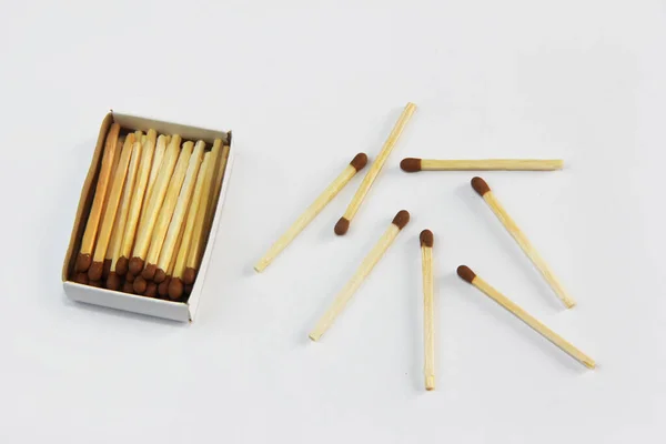 yellow wooden matches for lighting in a cardboard box on a white background