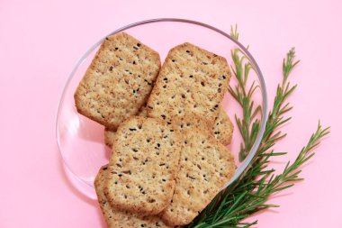 Dekoratif tabakta siyah kimyon ve kinoa içeren kuru kare diyet krakerleri.