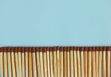 yellow wooden matches with brown sulfur heads on a blue background