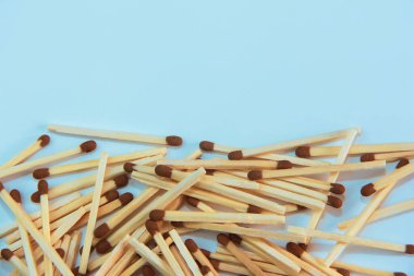 yellow wooden matches with brown sulfur heads on a blue background