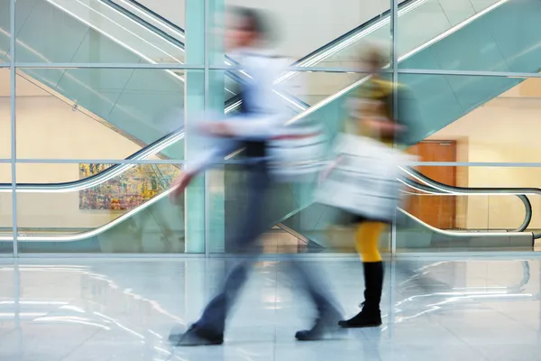 Företagare gå snabbt med bagage ner hall i office — Stockfoto