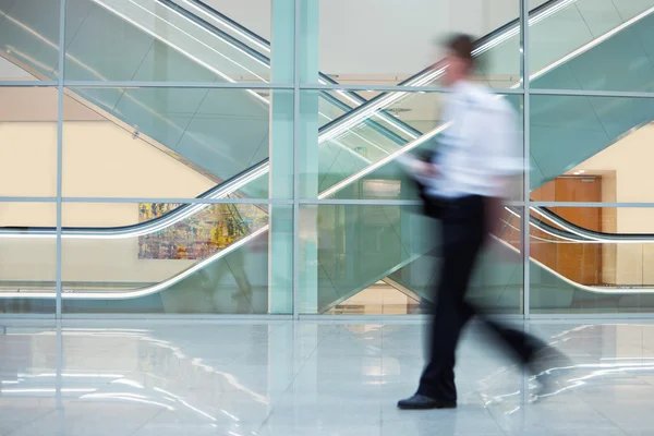 Empresário caminhando rapidamente pelo Hall no prédio do escritório — Fotografia de Stock