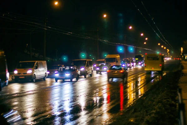 夕方の写真 車はヘッドライト付きの夜の都市の道路上で運転します — ストック写真