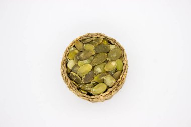 Kabak tohumları sepetin içinde, beyaz arkaplanda.
