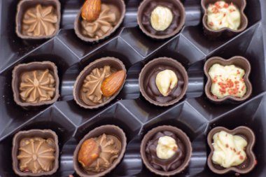 Açık kahverengi kutuda birkaç çikolata var.