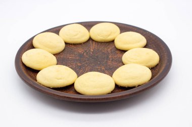 Kahverengi tabakta kremalı birkaç parça limonlu bisküvi.