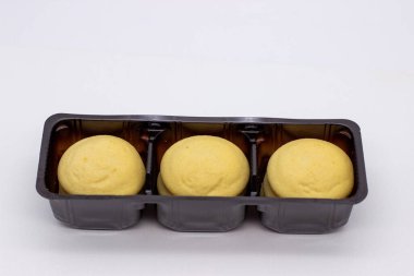 Kahverengi tabakta kremalı birkaç parça limonlu bisküvi.